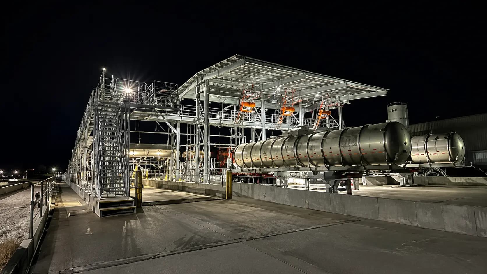 Night view of a process facility with pipe rack and vessels