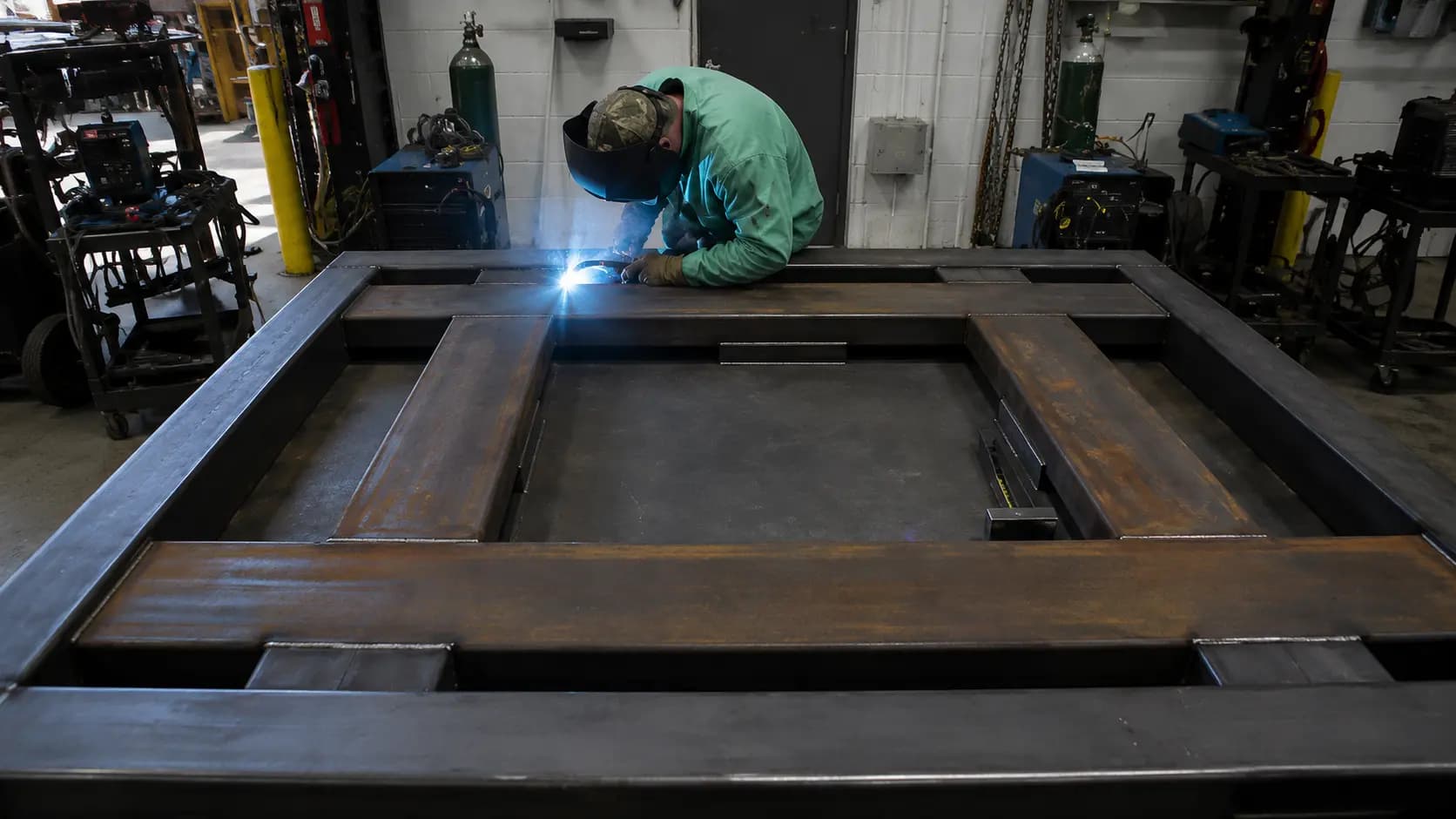 Welder working on a large rectangular fabricated steel frame