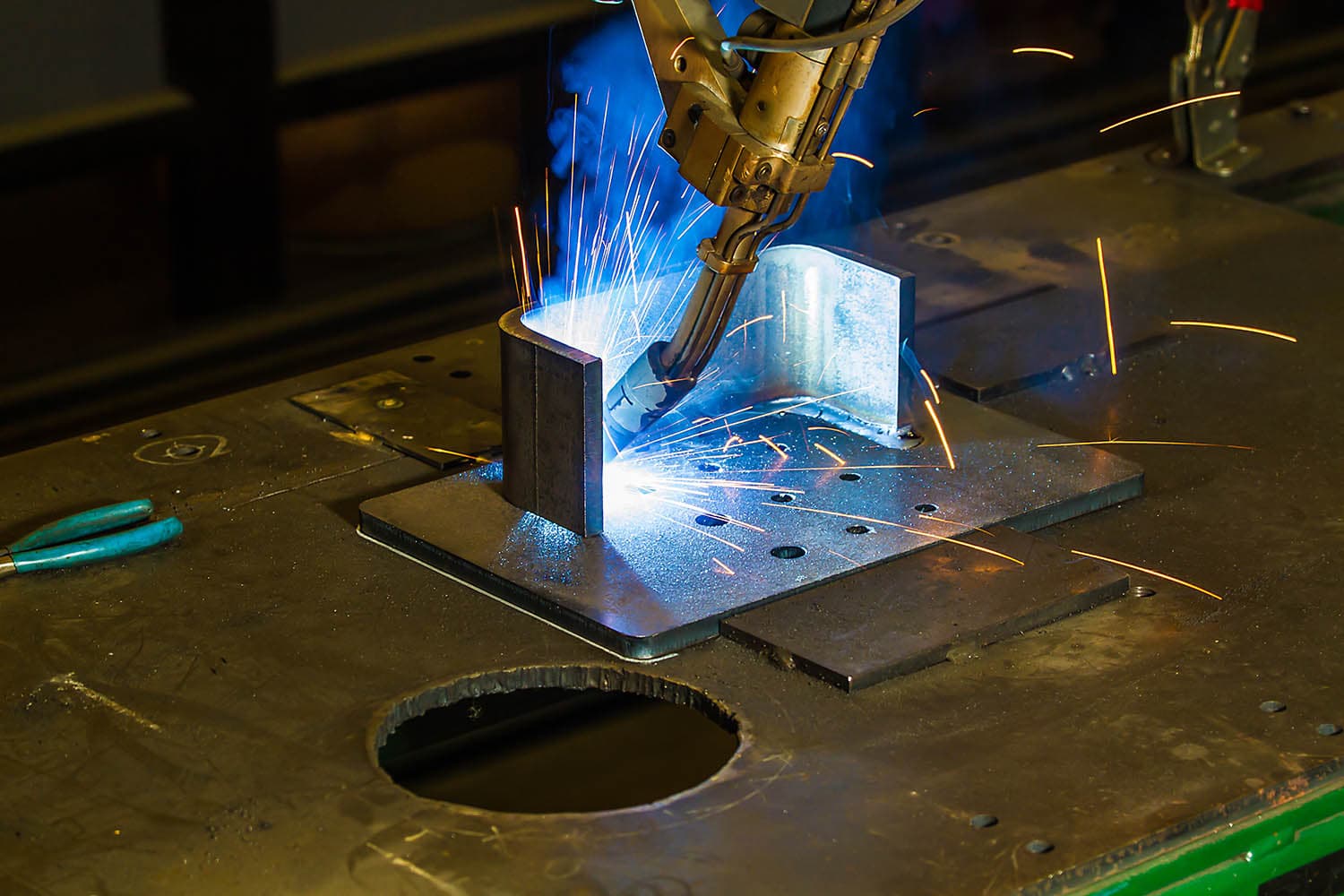 Robotic welding of a fabricated steel plate with sparks