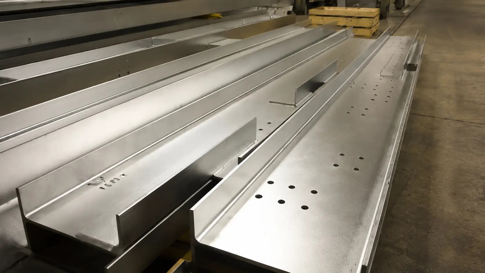 Fabricated structural steel members staged in the shop with bolt holes prepared