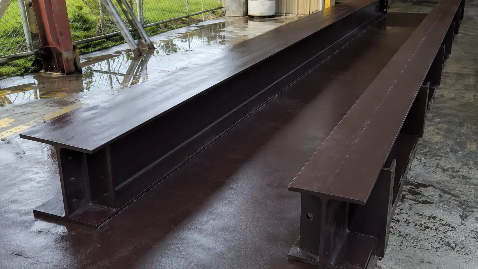 Large fabricated and painted steel girder staged for shipment