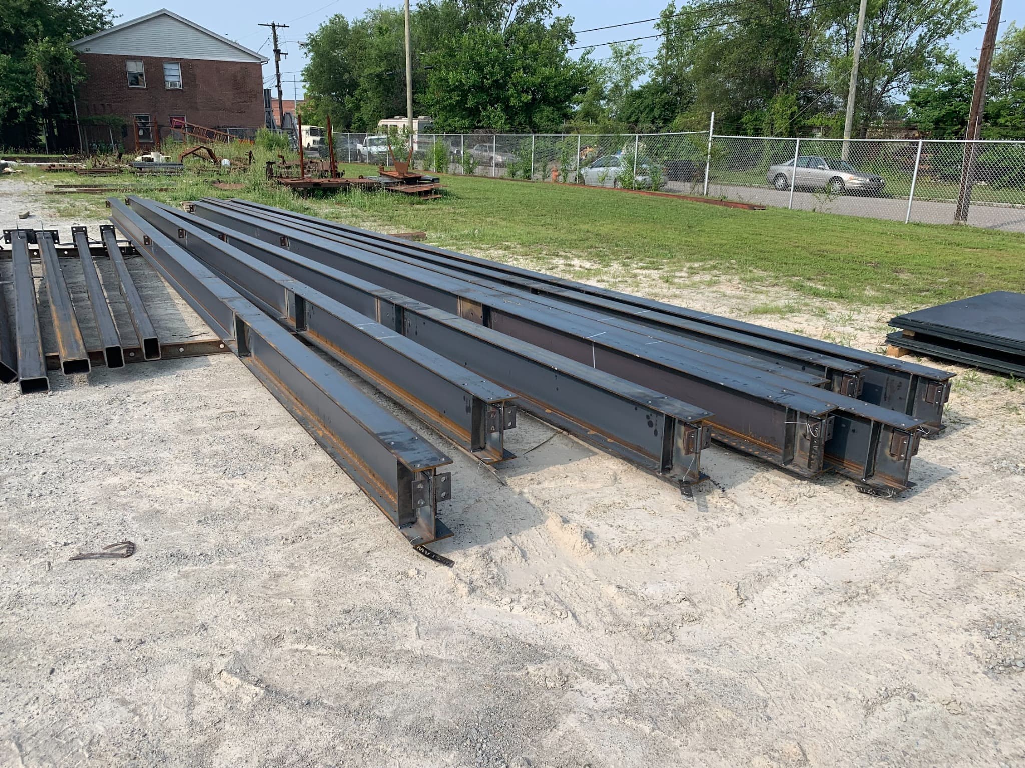 Fabricated steel beams staged in a row outdoors