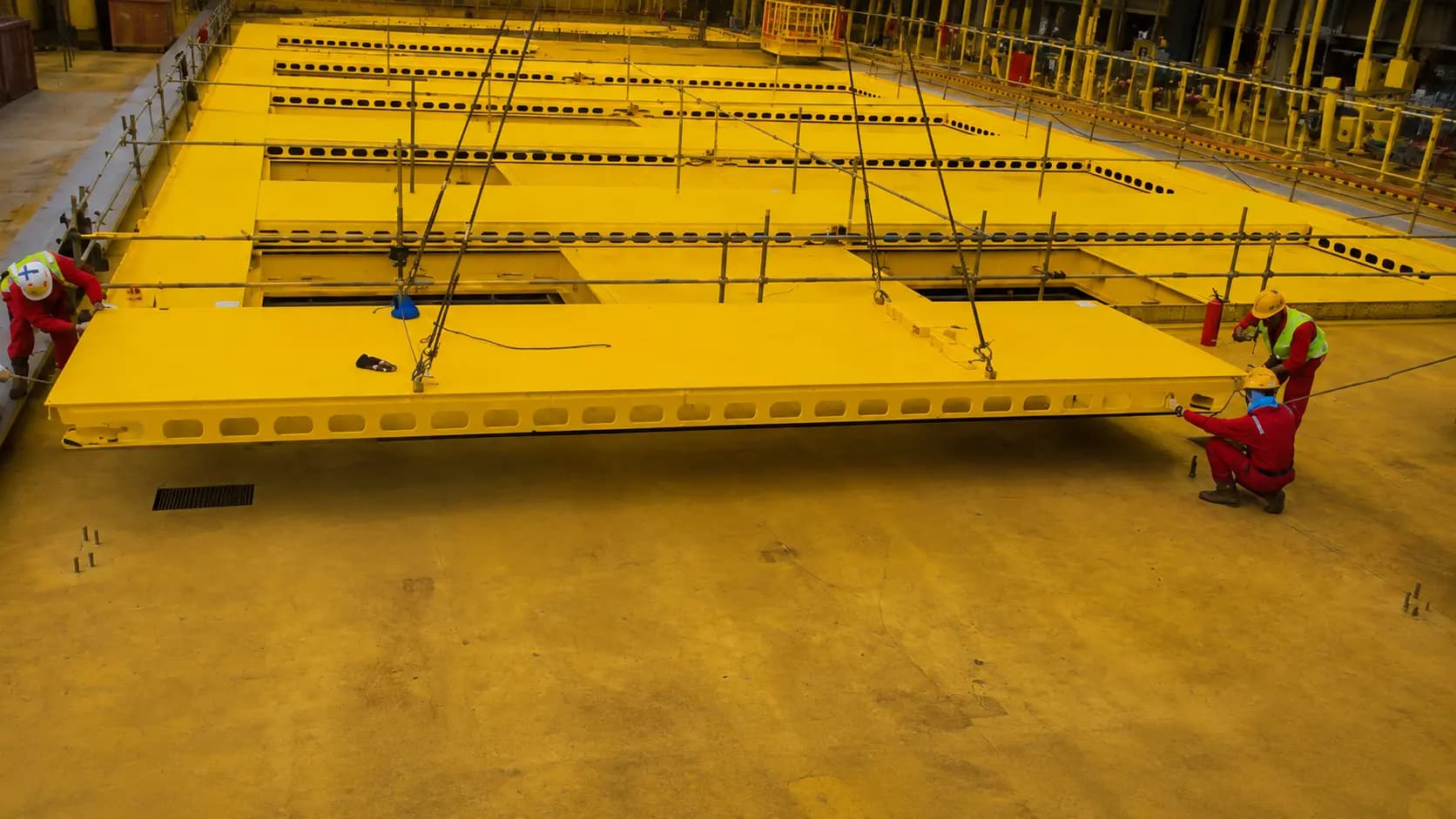 Large yellow-coated fabricated deck section in the shipyard