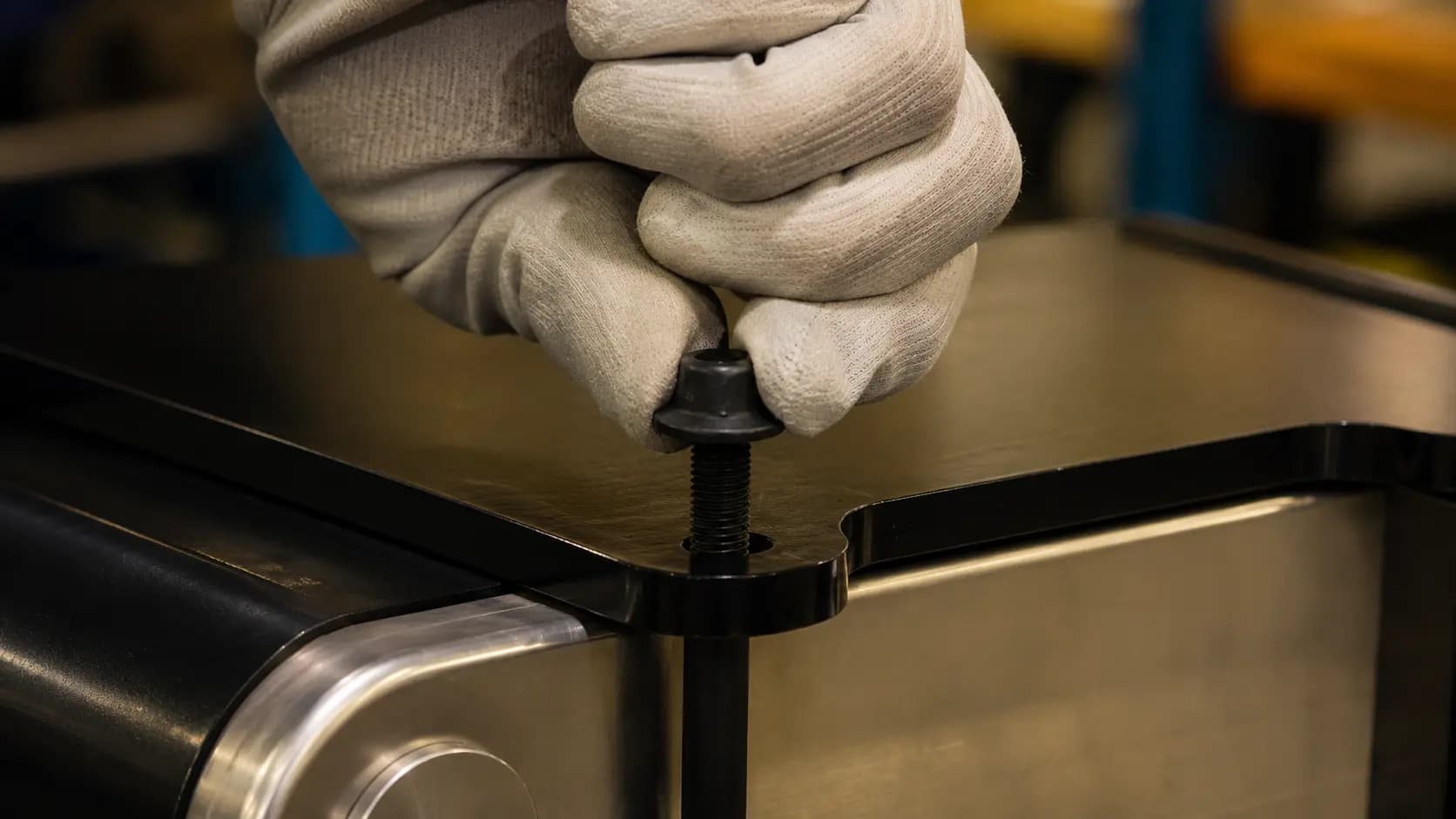 Gloved hands assembling a fabricated steel component