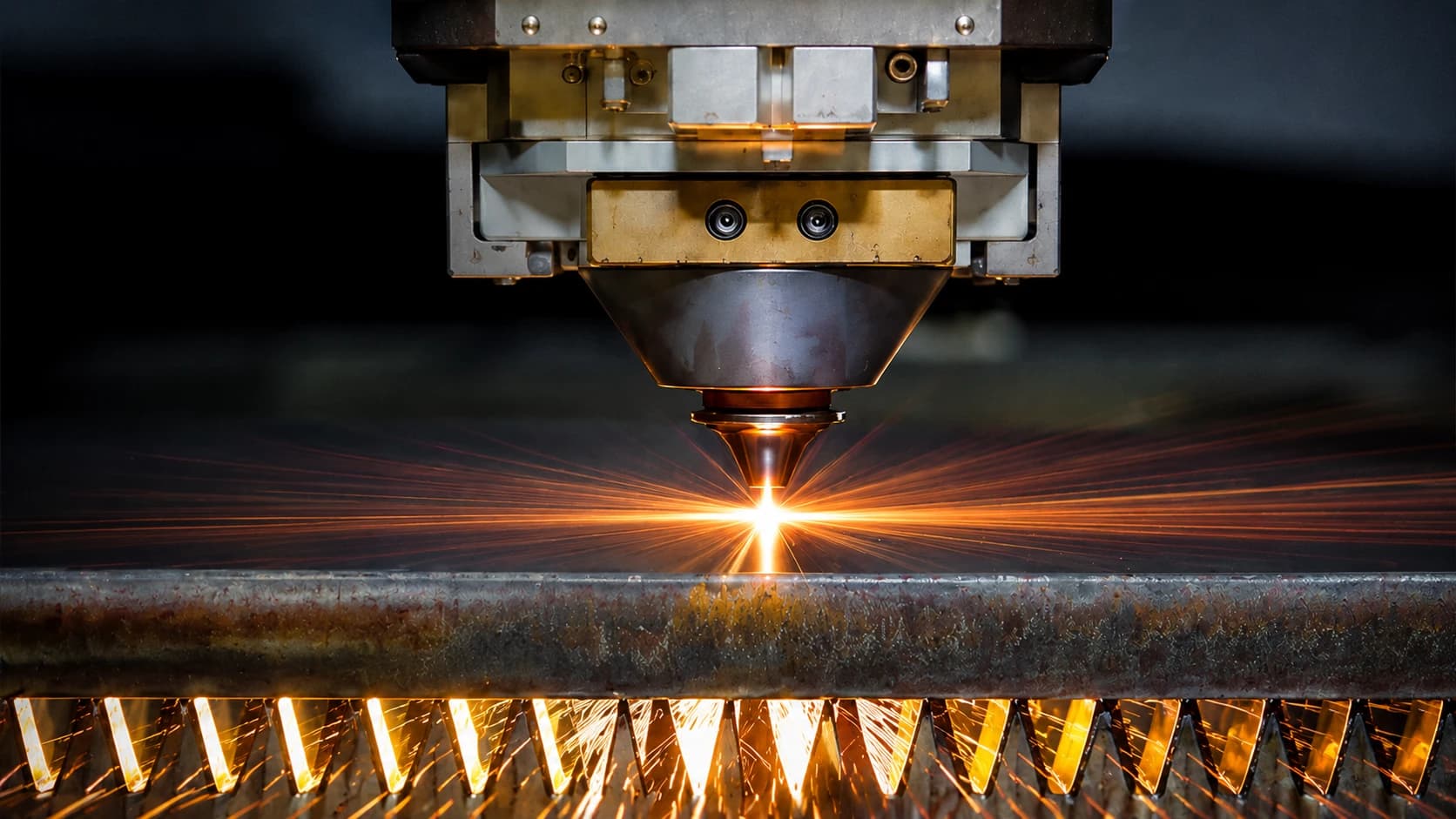 Fiber laser cutting head cutting steel with a shower of sparks